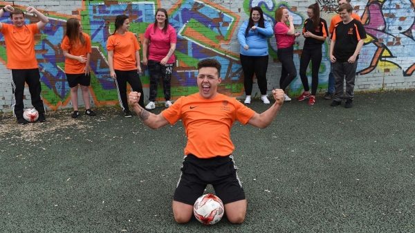 Person kneeling on the street teaching children about football